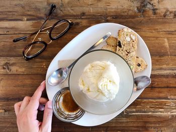 High angle view of hand holding tea cup on table