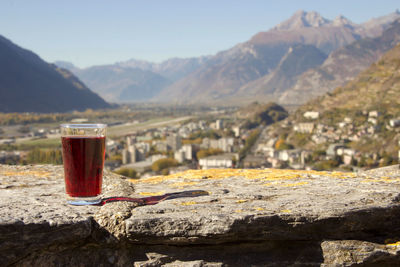 Close-up of drink on rock against sky