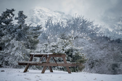 Gazebo on snow covered field against sky