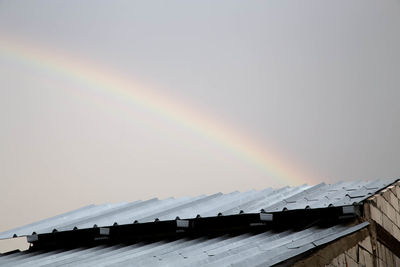 High section of house with rainbow against sky