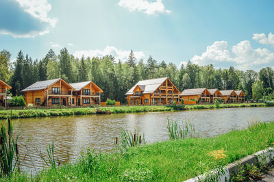 Houses by lake and buildings against sky