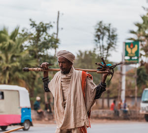 Man holding umbrella standing on road