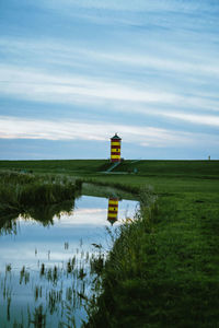 Lighthouse by sea against sky