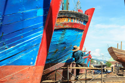 Ship moored in water against blue sky