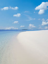 Scenic view of beach against blue sky