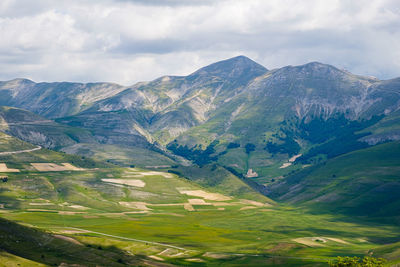 Scenic view of valley and mountains against sky