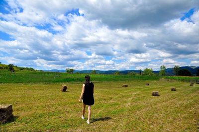 Woman standing on field against sky