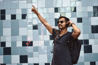 Young man looking at camera against wall