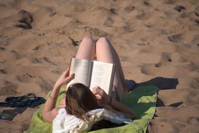 High angle view of woman lying on sand