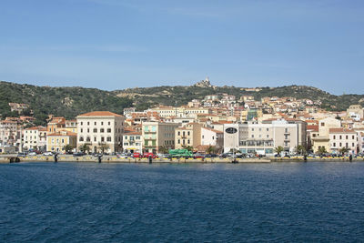 Town by sea against blue sky