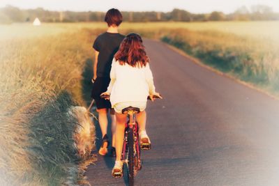 Rear view of couple walking on road