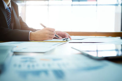 Midsection of businesswoman at table in office