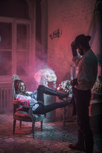 Couple wearing costume while relaxing at home during night