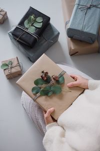 Midsection of woman with christmas presents at home