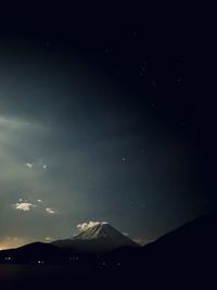 Scenic view of snowcapped mountain against cloudy sky