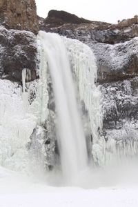 Scenic view of waterfall against sky