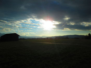 Scenic view of silhouette field against sky at sunset