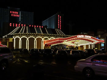 Illuminated ferris wheel in city at night