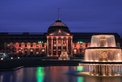 Reflection of illuminated building in water at night