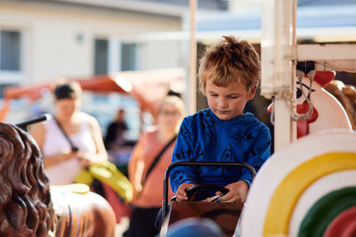 High angle view of boy sitting in city