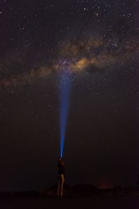 Full length of woman standing against star field at night