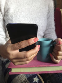 Midsection of man holding coffee cup