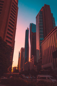 Low angle view of skyscrapers in city during sunset