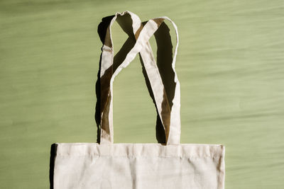 Reusable cotton shopping bag on green and beige background. zero waste concept. no plastic