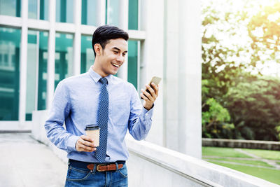 Young man using mobile phone in city