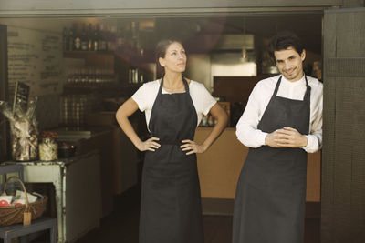 Portrait of owners standing outside cafe