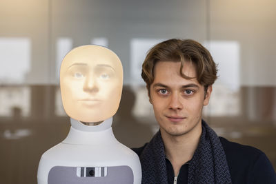 Portrait of young man with robot voice assistant