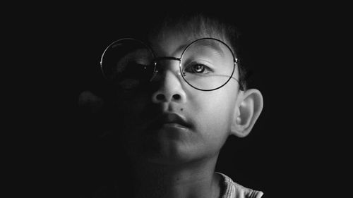 Portrait of happy boy against black background