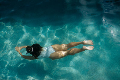 High angle view of woman swimming in pool under water 