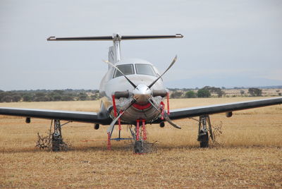 Airplane on airport runway against sky