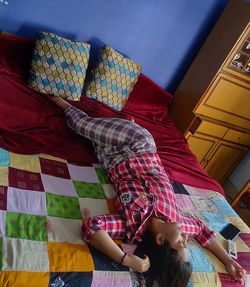 High angle view of woman relaxing on bed at home