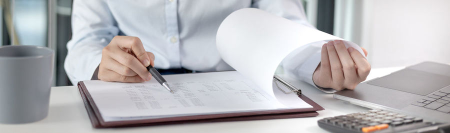 Midsection of businesswoman working on table