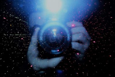 Close-up of hands against sky at night