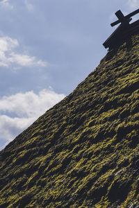 Low angle view of mountain against cloudy sky