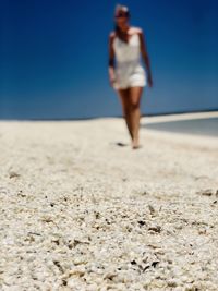 Full length of man standing on beach against clear sky