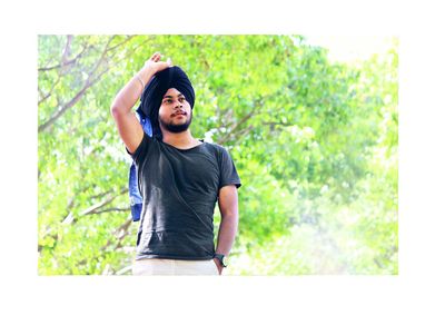 Young man standing against plants