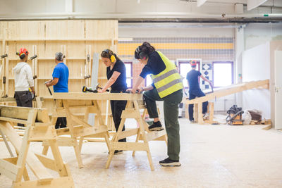 Carpenters working at illuminated workshop