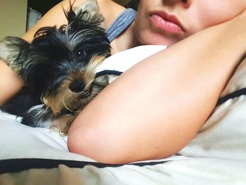 Close-up of woman with dog on bed