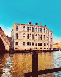 View of building by river against clear sky