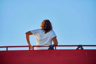 Rear view of woman standing against clear sky