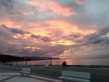 Scenic view of sea against cloudy sky at sunset