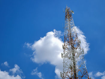 Low angle view of communications tower against blue sky