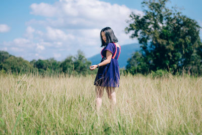 Young woman standing on grassy field