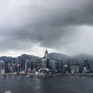 Buildings in city against cloudy sky