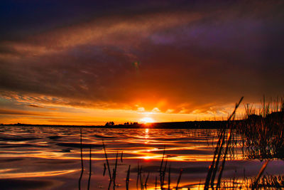 Scenic view of sea against dramatic sky during sunset