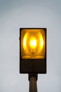 Low angle view of illuminated street light against sky